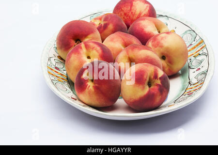 Frische Pfirsiche in eine Platte auf weißem Hintergrund Stockfoto