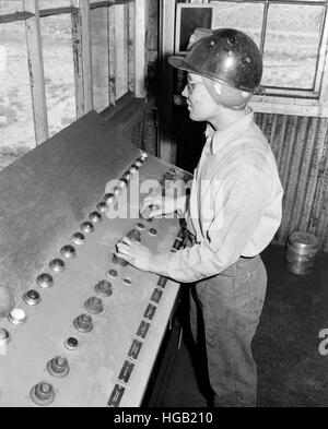 Mädchen-Steuerelemente laden der Kohle in Autos mittels Drucktasten, 1946. Stockfoto