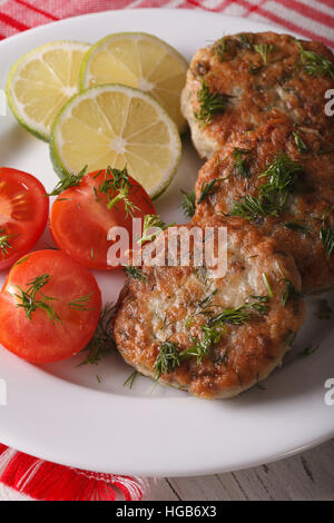 Lecker gebratene Fischfrikadellen mit Kräuter-close-up auf einem weißen Teller. vertikale Stockfoto