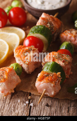 Gegrillter Lachs und Gemüse auf Spieße Makro auf dem Tisch. vertikale Stockfoto