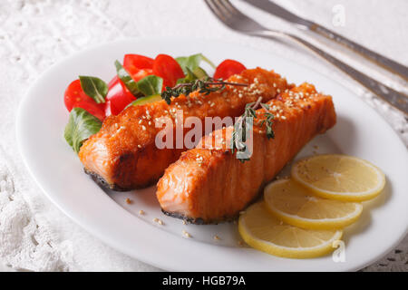 Gegrillter Lachs mit Zitrone und frischem Salat auf der Platte Nahaufnahme. Horizontale Stockfoto