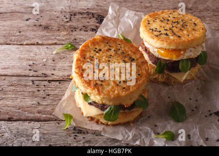 Ramen-Burger mit Rindfleisch und Ei auf einem Papier auf einem Holztisch Closeup. Horizontale Stockfoto