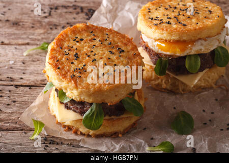 Ramen-Burger mit Rindfleisch und Ei auf einem Papier auf einem Holztisch. Horizontale Stockfoto