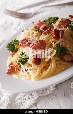 Pasta Carbonara mit Parmesan und Kräutern Closeup auf einem Teller auf den Tisch. Vertikal Stockfoto