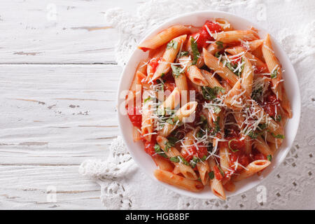 Arrabbiata Pasta Penne mit Parmesan-Käse auf einem Teller. horizontale Ansicht von oben Stockfoto