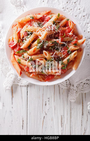 Arrabbiata Pasta Penne mit Parmesan-Käse auf einem Teller. vertikale Ansicht von oben Stockfoto