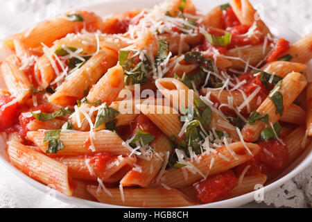 Arrabbiata Pasta Penne mit Parmesan-Käse auf einem Teller-Makro. horizontale Stockfoto