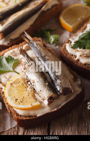 Leckere Fischbrötchen mit Sprotten und Frischkäse-close-up auf dem Tisch. vertikale Stockfoto