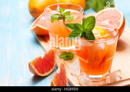 Rosa Cocktail mit Eis und frische Grapefruit, Minze auf einem hölzernen Hintergrund Stockfoto