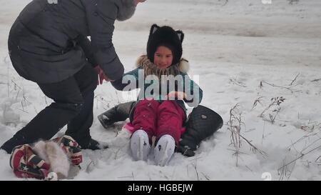 MOM bringt auf Skates Tochter Winterschnee, Urlaub mit der Familie Mädchen Stockfoto