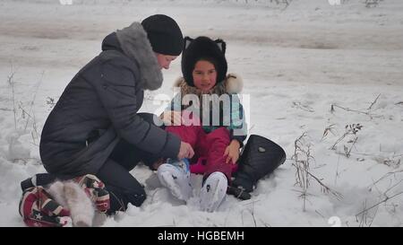 MOM bringt auf Skates Tochter Winterschnee, Urlaub mit der Familie Mädchen Stockfoto