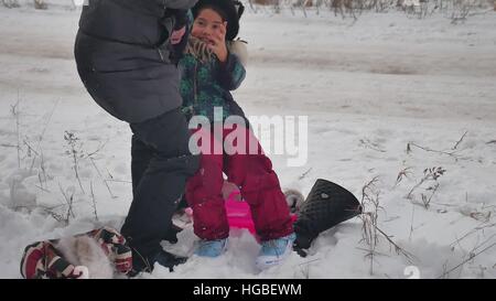 MOM bringt auf Skates Tochter Winterschnee, Urlaub mit der Familie Mädchen Stockfoto