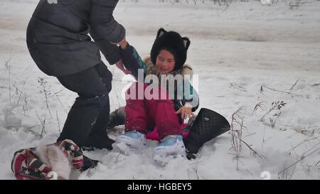 MOM bringt auf Skates Tochter Winterschnee, Urlaub mit der Familie Mädchen Stockfoto