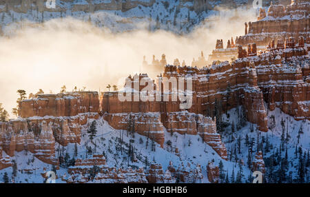 Ein Grat der Hoodoos mit Schnee bedeckt und Silhouette gegen den Nebel in Bryce-Canyon-Nationalpark, Utah Stockfoto