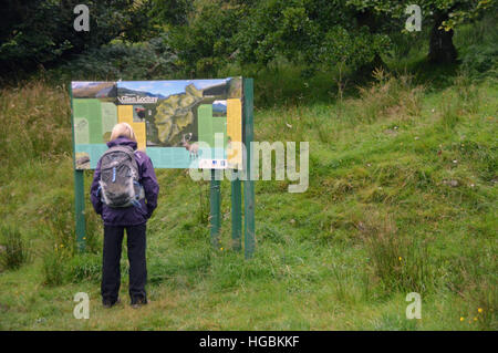 Frau Walker, Blick auf die touristischen Infotafel am Parkplatz in Glen Lochay in den schottischen Highlands Schottland, Großbritannien. Stockfoto