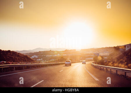 Malaga, Spanien - 20. Juni 2015: Die Bewegung von Fahrzeugen auf Autobahn, Autobahn e-15 in der Nähe von Malaga in Spanien. Sonnenuntergang Stockfoto