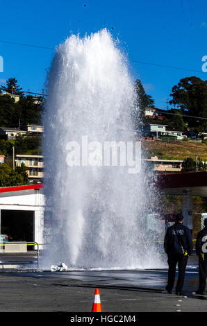 Ein Hydranten, unterbrochen von einem LKW erzeugt einen Geysir und kleine Überschwemmung in San Leandro, Kalifornien Stockfoto