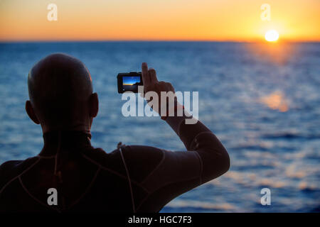 Ein Tourist Fotografieren bei Sonnenaufgang in Los Islotes Seelöwen Rookery, Sea of Cortez, Baja California, Mexiko. Kalifornische Seelöwen Zalophus californianu Stockfoto