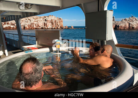 Touristen in der Hydromassage-Badewanne der Safari Endeavour entspannende Kreuzfahrt verankerte vor Los Islotes Seelöwen-Kolonie, Sea of Cortez Baja Ca Stockfoto