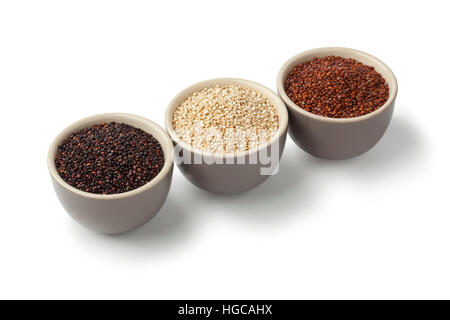 Schalen mit rohen roten, weißen und schwarzen Quinoa auf weißem Hintergrund Stockfoto