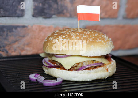 Hamburger mit Rindfleisch, Käse, Zwiebeln, Tomaten und Soße. Hausgemachte Burger. Polnische Flagge Stockfoto