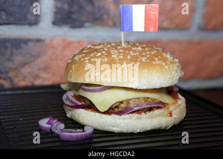 Hamburger mit Rindfleisch, Käse, Zwiebeln, Tomaten und Soße. Hausgemachte Burger. Französische Flagge Stockfoto