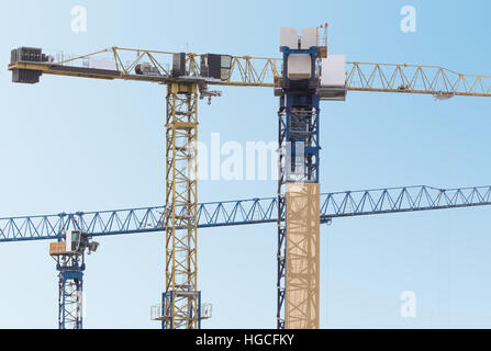 Drei Baukräne auf dem blauen Himmelshintergrund Stockfoto