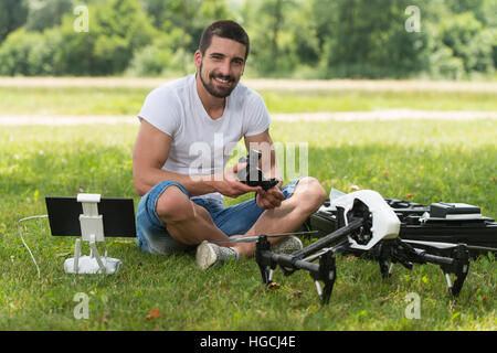 Nahaufnahme der junge Ingenieur Mann überprüfen die Kamera von einer Drohne mit Hand im Park Stockfoto