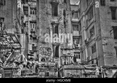 Eine verwitterte Gebäude bedeckt Graffiti in Tang Lung Street, Hong Kong Stockfoto