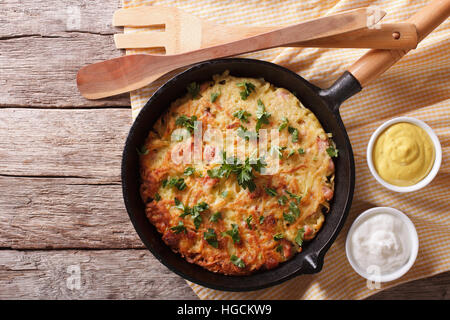 Rustikale Kartoffelpuffer mit Kräutern in einer Pfanne auf dem Tisch. Horizontale Ansicht von oben Stockfoto