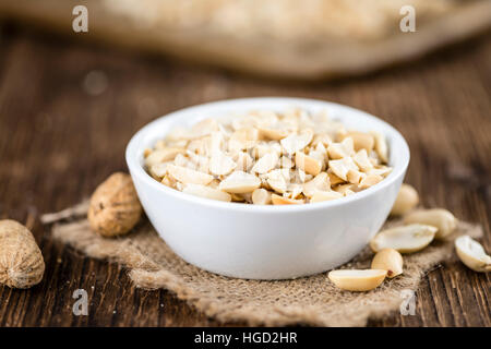 Einige gehackte Erdnüsse (close-up erschossen; selektiven Fokus) auf hölzernen Hintergrund Stockfoto