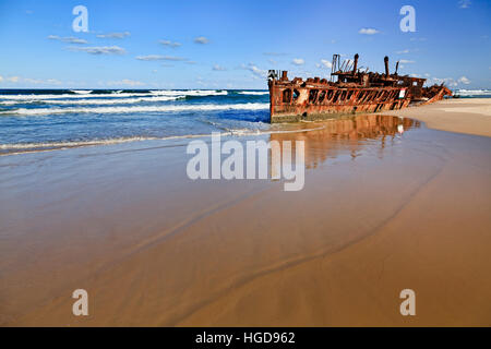 SS Maheno Schiffswrack auf sandigen Strand von Fraser Island gegen öffnen Pazifischen Ozean Horizont. Leeren Strand saugt glatte flache Wellen reflektiert rostig Stockfoto