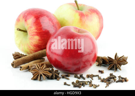 Drei glänzende frische rote Elstar Äpfel (Malus Domestica) mit Zimt und Sternanis, auf einem weißen Hintergrund. Stockfoto