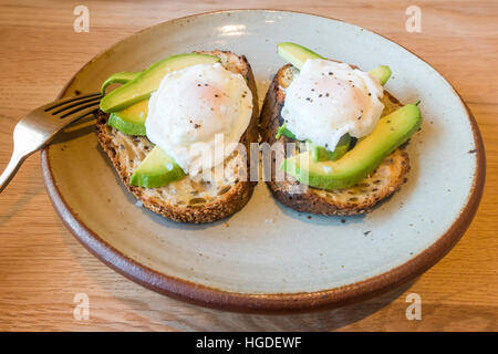 Mittagessen Open Sandwich von zwei pochierten Eiern auf Avocado und geröstetes Sauerteigbrot Stockfoto