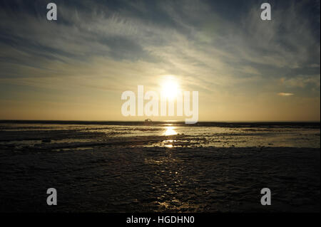 Blick über Meer Eis Sand Strand in Richtung Sand preisgekrönte Digger und weiße Sonne sinkende grau-weißen Wolken, nördlich von St. Annes, UK Stockfoto