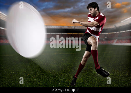 Rugby-Spieler in einer roten Uniform einen Ball auf das Stadion Stockfoto