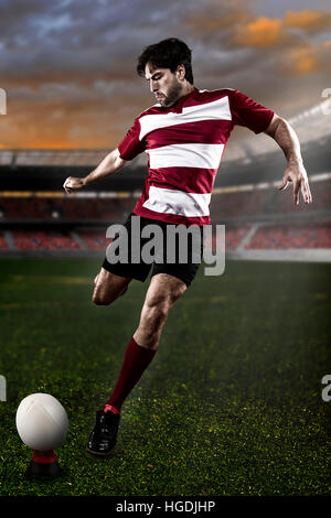 Rugby-Spieler in einer roten Uniform einen Ball auf das Stadion Stockfoto