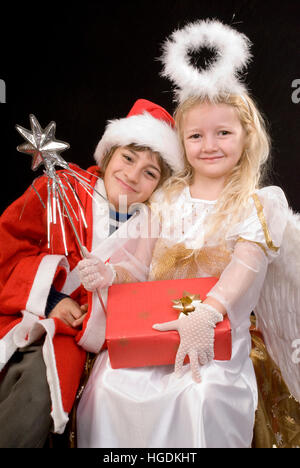 Kinder als Weihnachtsmann und Christkind Stockfoto