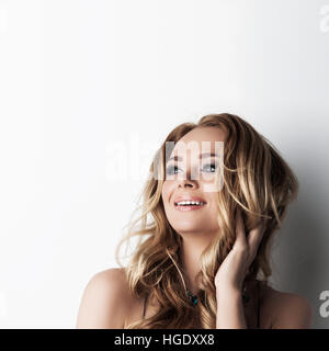 Porträt von schön aufgeregt blonden Mädchen mit langen lockigen Haaren betrachten Textfreiraum Stockfoto