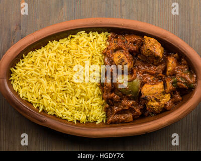 Frisch zubereitete Authentische indische Stil würzig Jalfrezi Huhn Curry serviert mit gelber Reis Pilaw Mahlzeit ohne Menschen und Flach Zusammensetzung Stockfoto