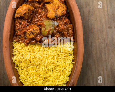 Frisch zubereitete Authentische indische Stil würzig Jalfrezi Huhn Curry serviert mit gelber Reis Pilaw Mahlzeit ohne Menschen und Flach Zusammensetzung Stockfoto