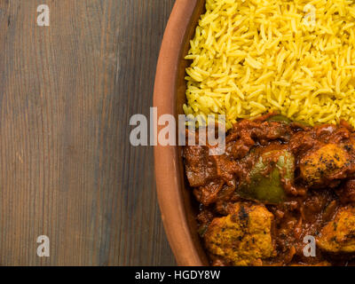 Frisch zubereitete Authentische indische Stil würzig Jalfrezi Huhn Curry serviert mit gelber Reis Pilaw Mahlzeit ohne Menschen und Flach Zusammensetzung Stockfoto