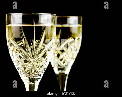 Gekühlten Weißwein in einen Schnitt Kristallglas vor schwarzem Hintergrund Stockfoto