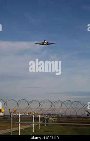 Ein Flugzeug fliegt über den Sicherheitszaun in Stuttgart Airport in Stuttgart, Deutschland. Stockfoto