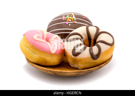 Leckere Donuts in Holzplatte auf weißem Hintergrund Stockfoto