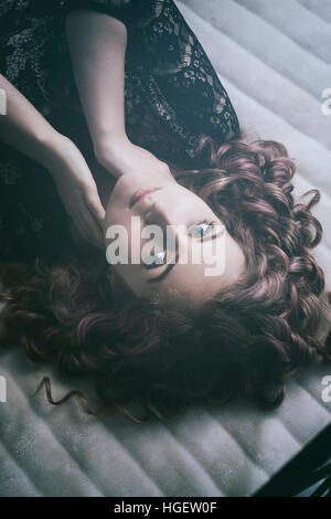 Schöne junge Frau im Bett Hände berühren Nacken Festlegung Stockfoto