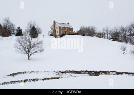 Haus auf einem schneebedeckten Hügel, in einer ländlichen Gegend von Carroll County, Maryland. Stockfoto