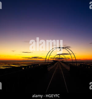 Suche entlang Southport Pier bei Sonnenuntergang, Merseyside, Lancashire, England, UK. Stockfoto