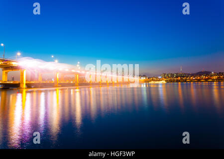 Wasser spritzt von Seite der Banpo-Brücke in den Han-Fluss bei Mondschein-Regenbogen-Brunnen-Licht-Show in der Dämmerung in Seoul Stockfoto