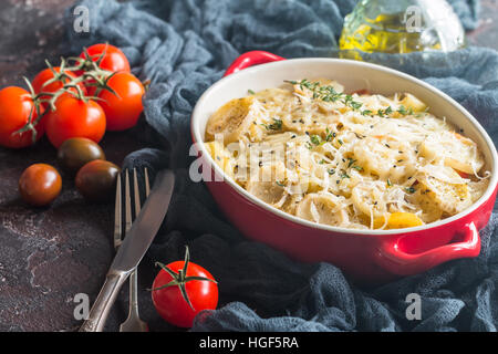 Kartoffel-Gratin, im rustikalen Gericht. Köstliche Kartoffelscheiben mit Zwiebeln, Tomaten, Knoblauch, Kräuter und Hühnerfleisch. Stockfoto